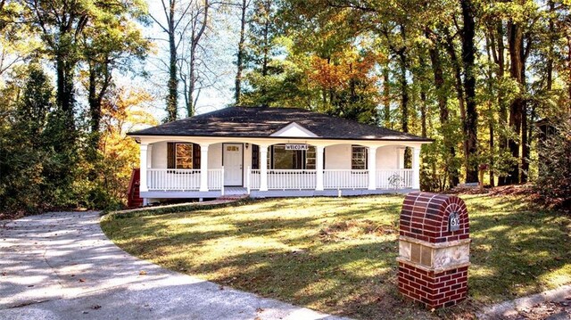 ranch-style home featuring a front lawn and a porch