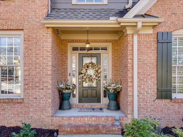 entrance to property with brick siding and roof with shingles