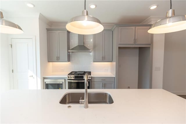 kitchen with stainless steel range, wall chimney range hood, pendant lighting, and decorative backsplash