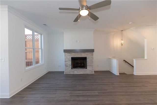 unfurnished living room with a fireplace, ceiling fan, ornamental molding, and dark hardwood / wood-style flooring