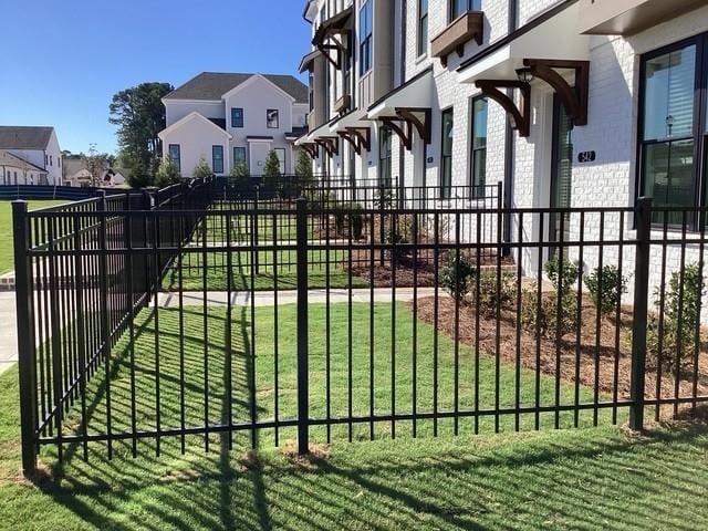 view of gate with a lawn