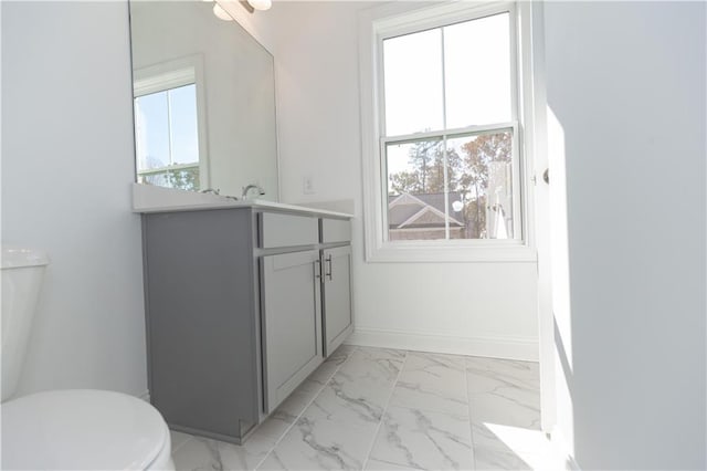 bathroom featuring toilet, vanity, and a wealth of natural light