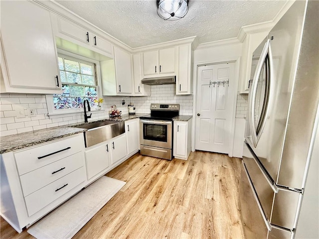 5347 Ocarol Ct, Stone Mountain, GA 30088 - kitchen featuring appliances with stainless steel finishes, under cabinet range hood, ornamental molding, white cabinets, and light wood-type flooring