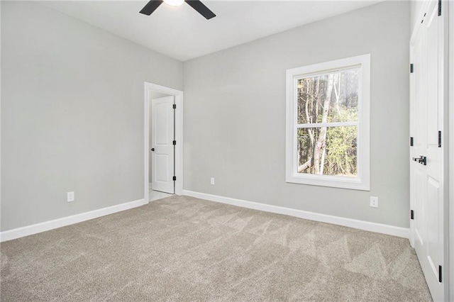 unfurnished bedroom with baseboards, connected bathroom, ceiling fan, and carpet