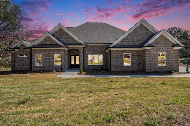 craftsman-style house with fence, an attached garage, driveway, a front lawn, and brick siding