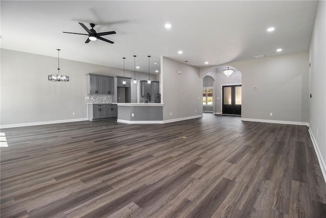 kitchen featuring visible vents, stainless steel electric range, a sink, gray cabinetry, and wall chimney range hood