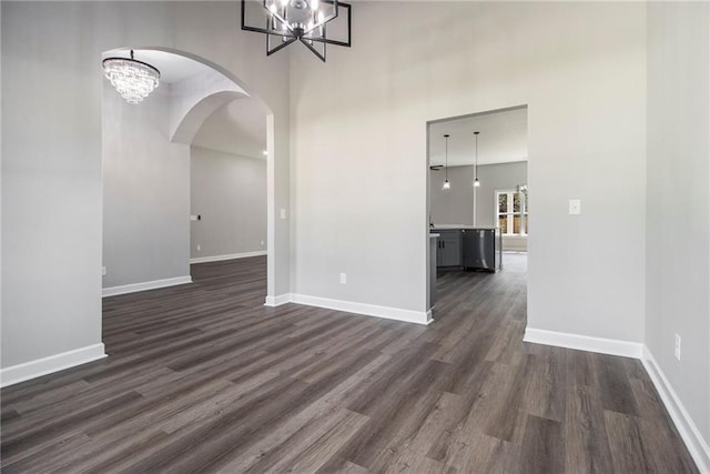 kitchen with gray cabinets, stainless steel appliances, a sink, wall chimney range hood, and wood finished floors