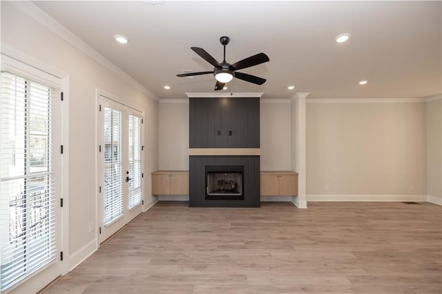 unfurnished living room featuring crown molding, ceiling fan, a fireplace, and light hardwood / wood-style flooring