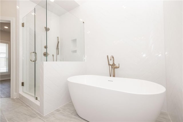 bathroom with separate shower and tub, tile walls, and tile patterned floors