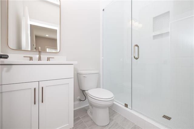 bathroom featuring vanity, an enclosed shower, and toilet