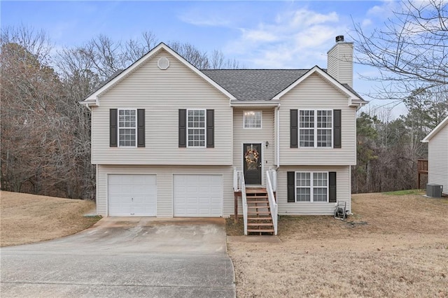 split foyer home with a garage and central air condition unit