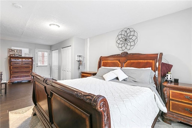 bedroom with dark wood-type flooring and a textured ceiling