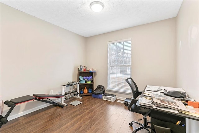 home office with a textured ceiling and dark hardwood / wood-style flooring