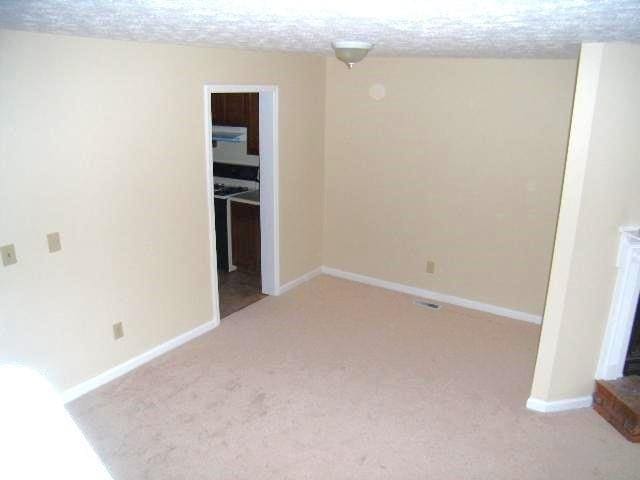 empty room featuring a textured ceiling and light carpet