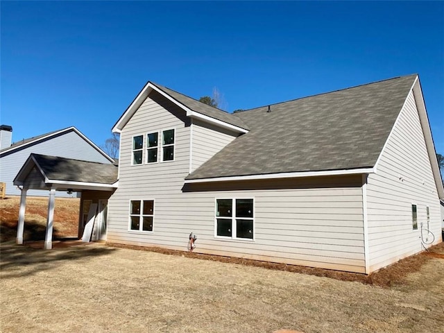 rear view of house featuring a shingled roof