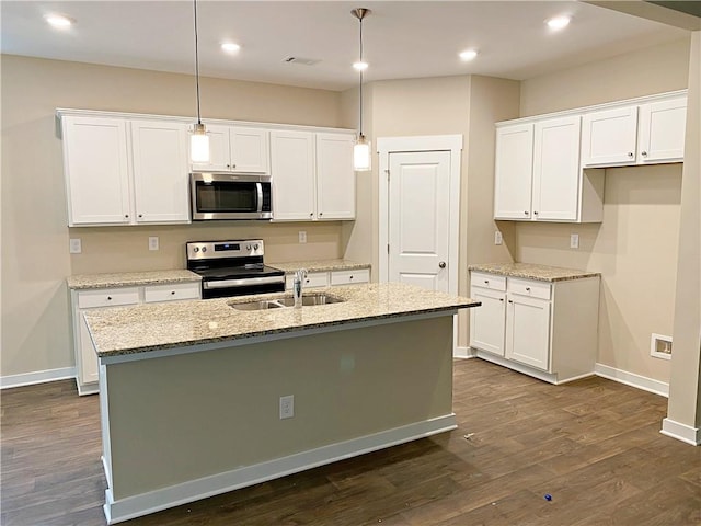 kitchen featuring white cabinets, a sink, stainless steel appliances, baseboards, and a center island with sink