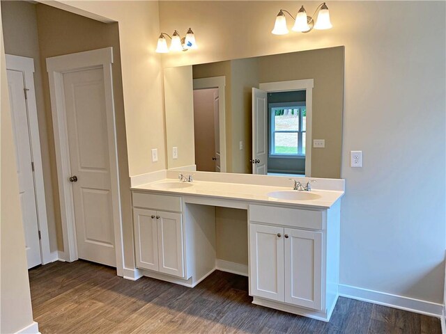 full bath with double vanity, a sink, and wood finished floors