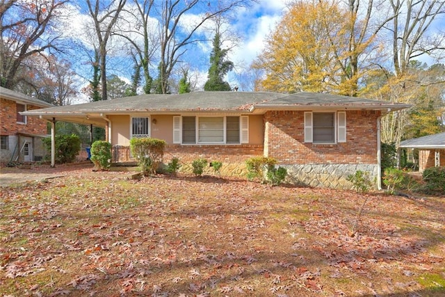 single story home featuring brick siding and a carport