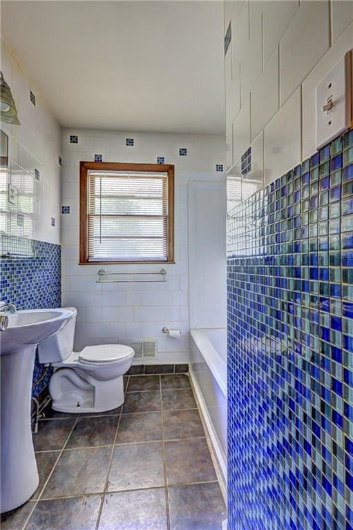 full bathroom with tile walls and toilet