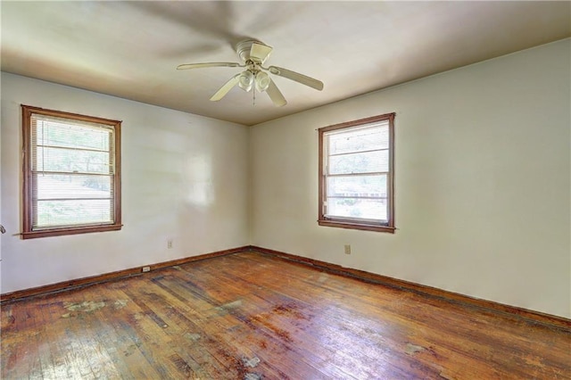empty room featuring baseboards, a ceiling fan, and wood-type flooring