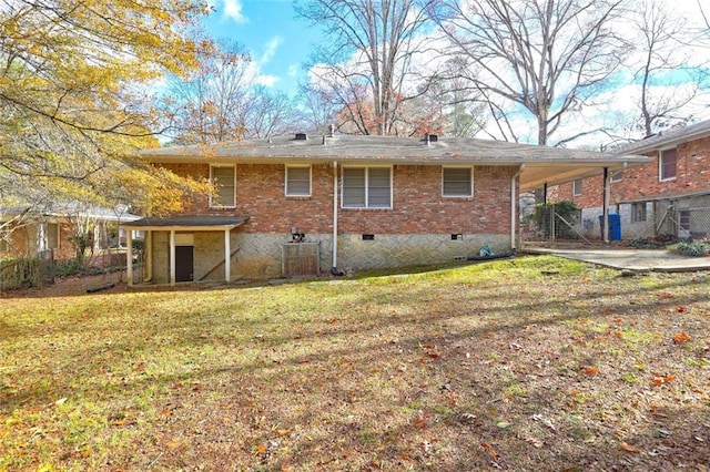 rear view of property with a yard, concrete driveway, a carport, and brick siding