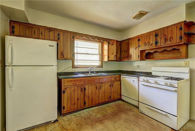 kitchen featuring brown cabinets, white appliances, dark countertops, and a sink