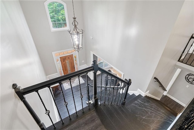 5041 Corinault Pl NW, Acworth, GA 30101 - staircase featuring a towering ceiling, wood finished floors, a chandelier, and baseboards