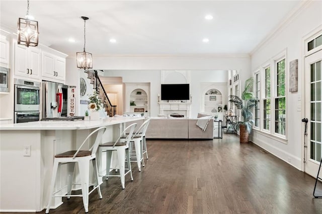 882 Hallbrook Ln, Milton, GA 30004 - kitchen with stainless steel appliances, crown molding, light countertops, dark wood-style floors, and white cabinetry