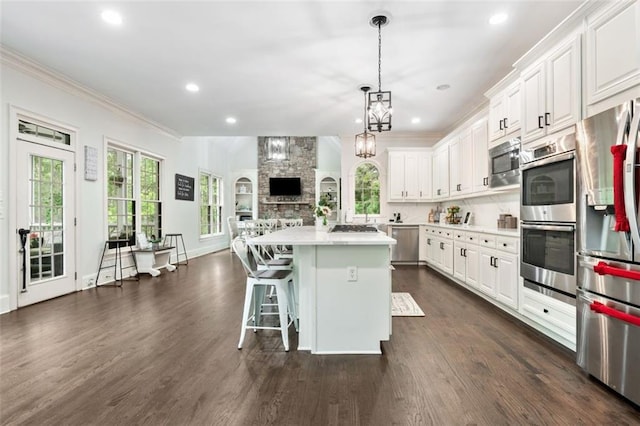 882 Hallbrook Ln, Milton, GA 30004 - kitchen with stainless steel appliances, open floor plan, healthy amount of natural light, crown molding, and light countertops