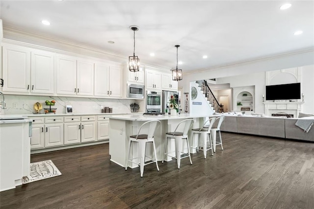 882 Hallbrook Ln, Milton, GA 30004 - kitchen with appliances with stainless steel finishes, a breakfast bar, white cabinets, light countertops, and crown molding