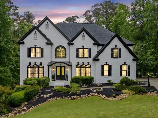 882 Hallbrook Ln, Milton, GA 30004 - back of house at dusk with a lawn, french doors, and stucco siding