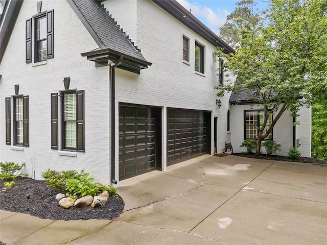 882 Hallbrook Ln, Milton, GA 30004 - view of side of home with a garage, brick siding, and driveway