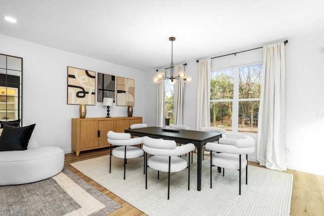 dining space with an inviting chandelier and light wood-type flooring