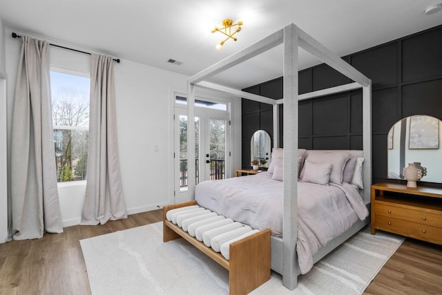 bedroom with wood-type flooring and access to exterior