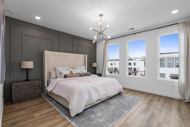 bedroom featuring a notable chandelier and light wood-type flooring