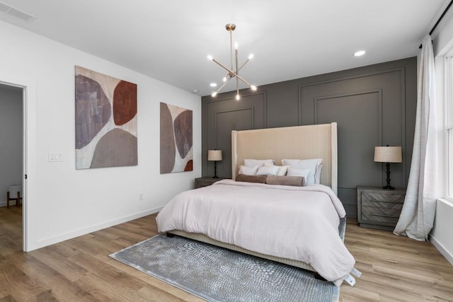 bedroom featuring light hardwood / wood-style flooring and a chandelier