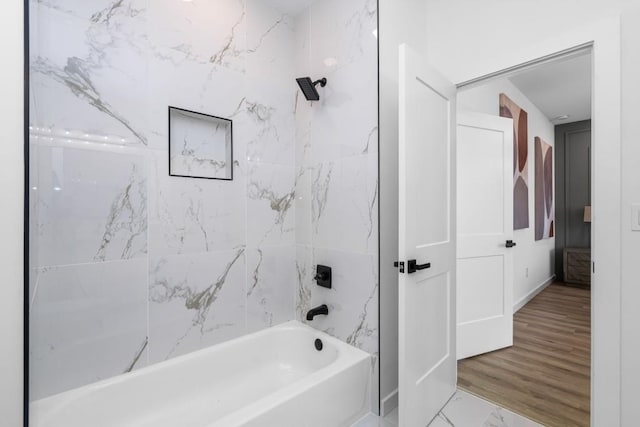 bathroom featuring tiled shower / bath combo and hardwood / wood-style flooring