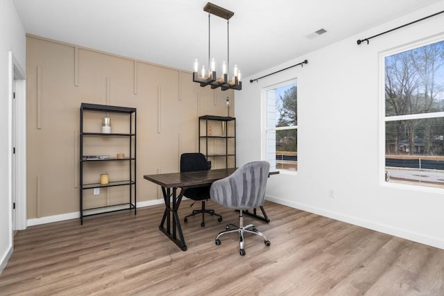 office space with an inviting chandelier and hardwood / wood-style flooring