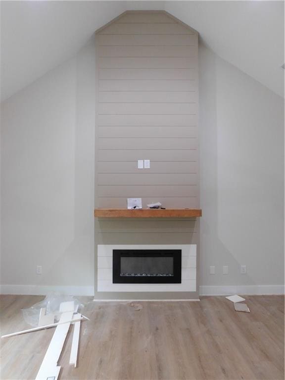 100 Elbert Gaddis Rd, Dahlonega, GA 30533 - unfurnished living room with vaulted ceiling, a large fireplace, wood finished floors, and baseboards