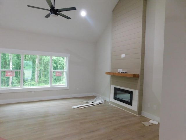 100 Elbert Gaddis Rd, Dahlonega, GA 30533 - unfurnished living room with a ceiling fan, a large fireplace, baseboards, wood finished floors, and high vaulted ceiling