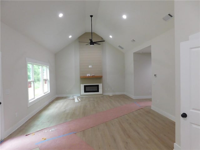 100 Elbert Gaddis Rd, Dahlonega, GA 30533 - unfurnished living room with light wood finished floors, a glass covered fireplace, vaulted ceiling, a ceiling fan, and baseboards