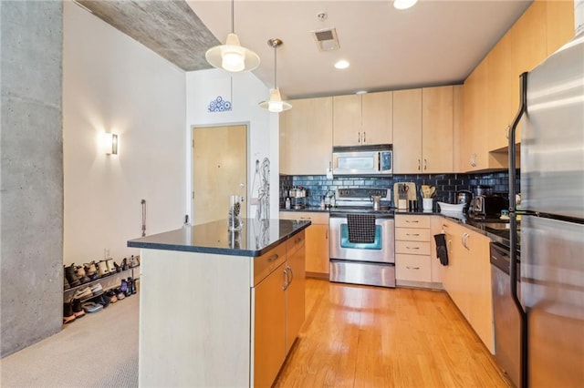 kitchen featuring a kitchen island, appliances with stainless steel finishes, decorative light fixtures, light brown cabinets, and light hardwood / wood-style flooring