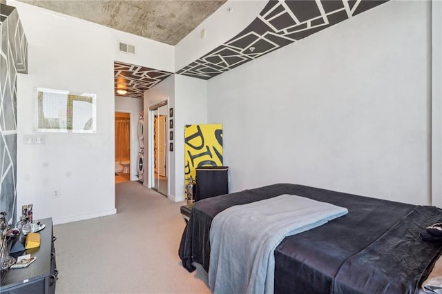 bedroom featuring connected bathroom, carpet, and washer / clothes dryer