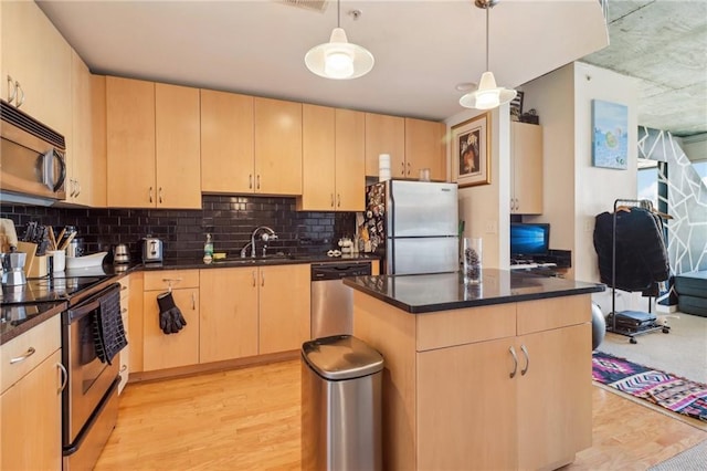 kitchen featuring light brown cabinetry, pendant lighting, light hardwood / wood-style floors, and stainless steel appliances