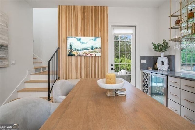 dining room with stairway, wine cooler, and a dry bar