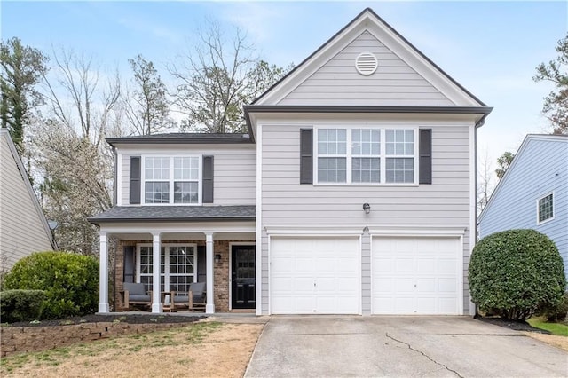 traditional-style home with a garage, covered porch, and concrete driveway