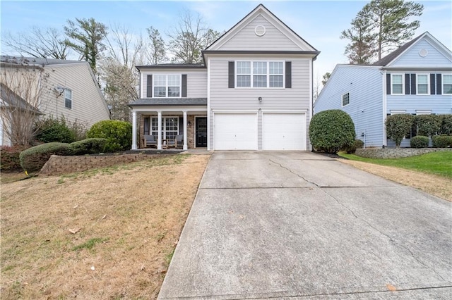 traditional-style house with an attached garage, concrete driveway, covered porch, and a front yard