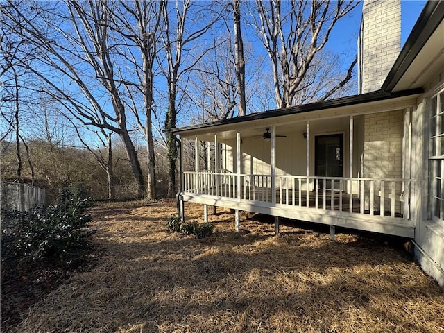 view of side of property featuring ceiling fan and covered porch