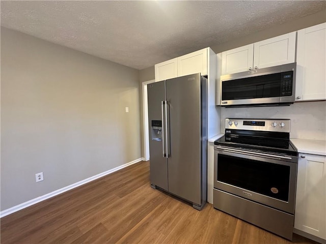 kitchen featuring a textured ceiling, stainless steel appliances, and white cabinets