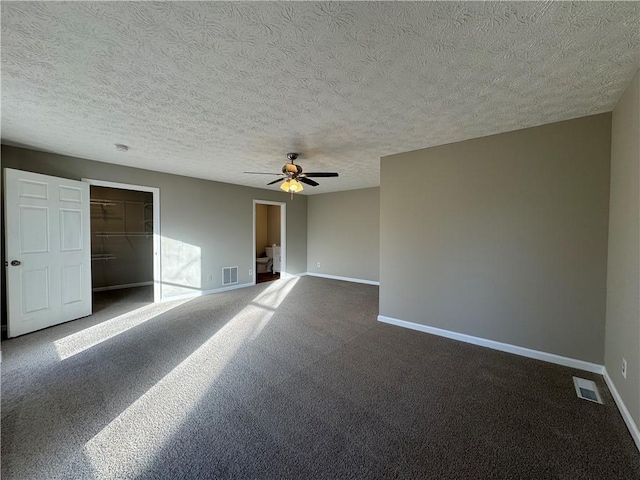 carpeted empty room with a textured ceiling and ceiling fan